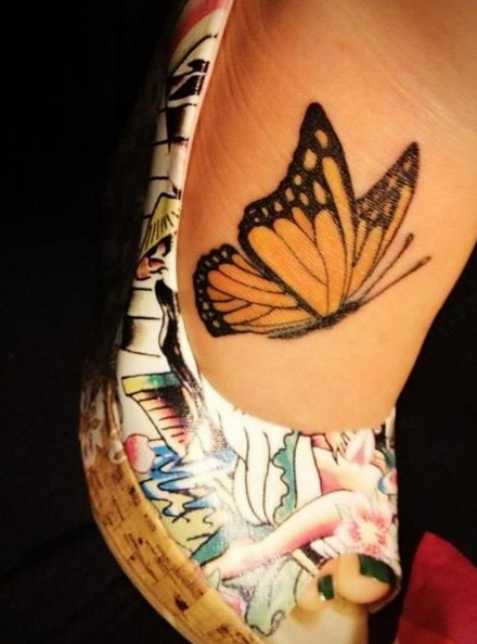 点击大图看下一张：女人脚背一只黄色的彩绘蝴蝶纹身