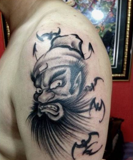 点击大图看下一张：男性手臂处水墨画风格钟馗纹身图案