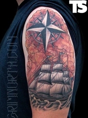 大臂上一款精细的帆船指南针纹身图案