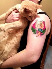 女子左手大臂上漂亮的彩色宠物猫纹身图片