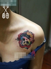 女生肩膀处潮流小巧的彩色骷髅纹身图案