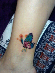 女人脚踝处漂亮的彩色蝴蝶刺青