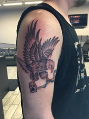 男孩右手大臂膀上的黑灰色老鹰纹身图片
