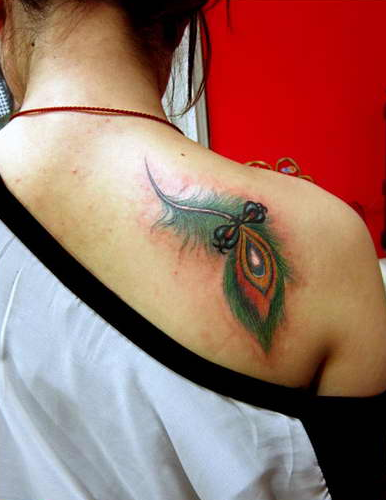 点击大图看下一张：女性背部孔雀羽毛纹身图片