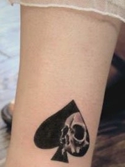 女孩子腿部一张黑桃与骷髅纹身图案