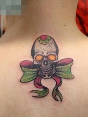 女孩子背部小巧的骷髅与蝴蝶结纹身图案