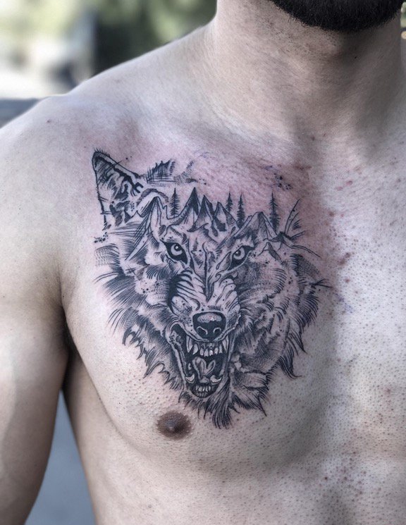 点击大图看下一张：男性胸部上黑灰色山峰和狼头纹身图片