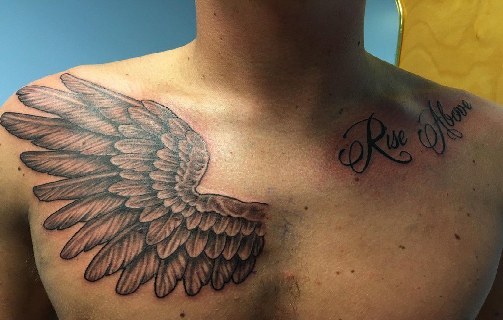 点击大图看下一张：男性锁骨上的英文字和右胸部上的一只天使翅膀纹身图片