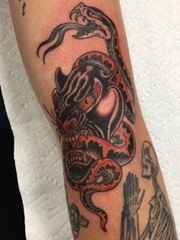 手臂上的传统风格豹子咬蛇纹身图片