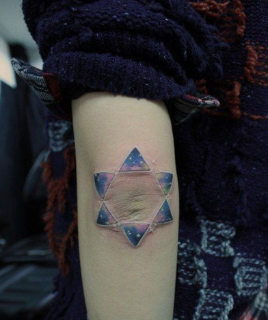 点击大图看下一张：女人手臂漂亮的彩色星空六芒星纹身