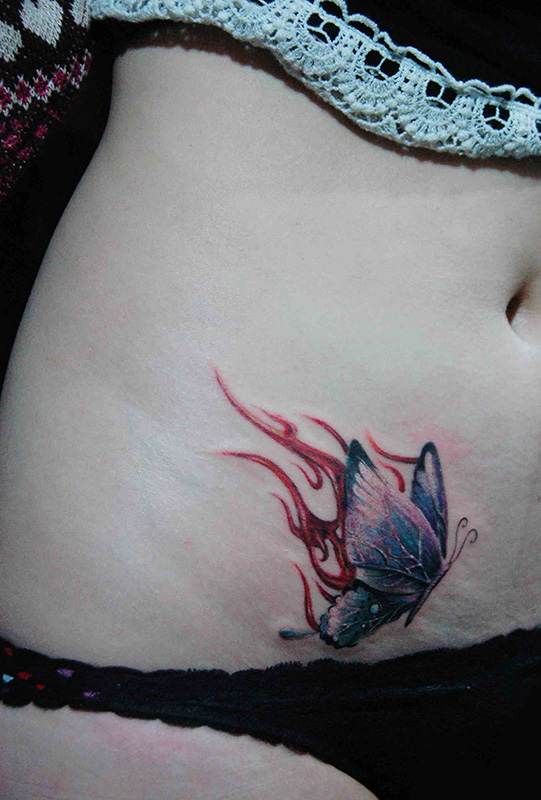 点击大图看下一张：浴火彩蝶美女腹部个性纹身