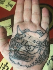 手掌上的带角的唐狮怪兽纹身