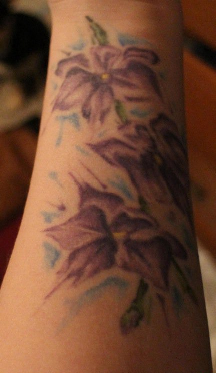 点击大图看下一张：手臂上的紫色花朵纹身