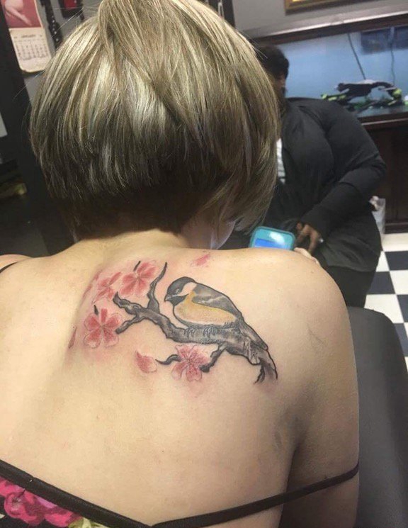 点击大图看下一张：女孩背上的站点花枝上的鸟纹身图片