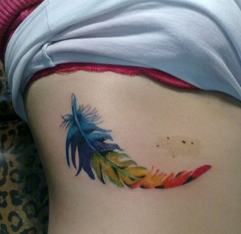 点击大图看下一张：肋部上漂亮的彩色羽毛纹身图案