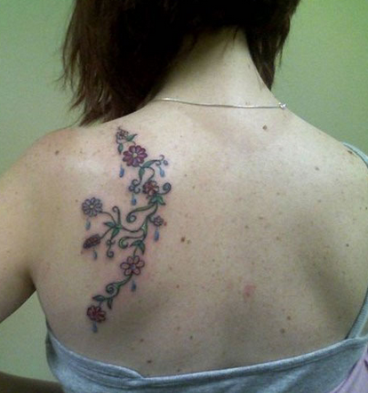 点击大图看下一张：女生左后背花蕊藤蔓纹身图案