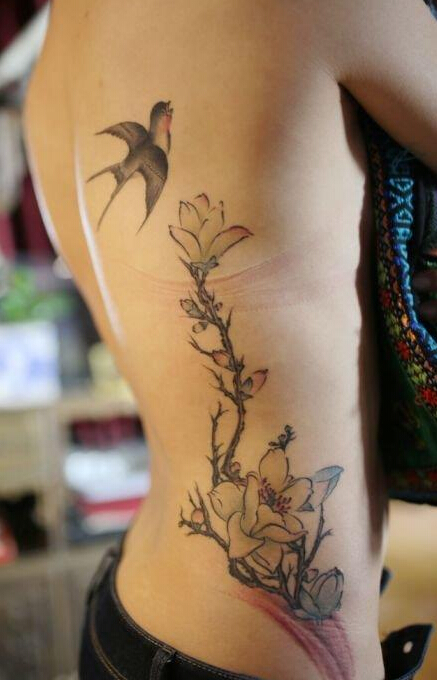 点击大图看下一张：女生腰部彩色燕子花卉纹身图片