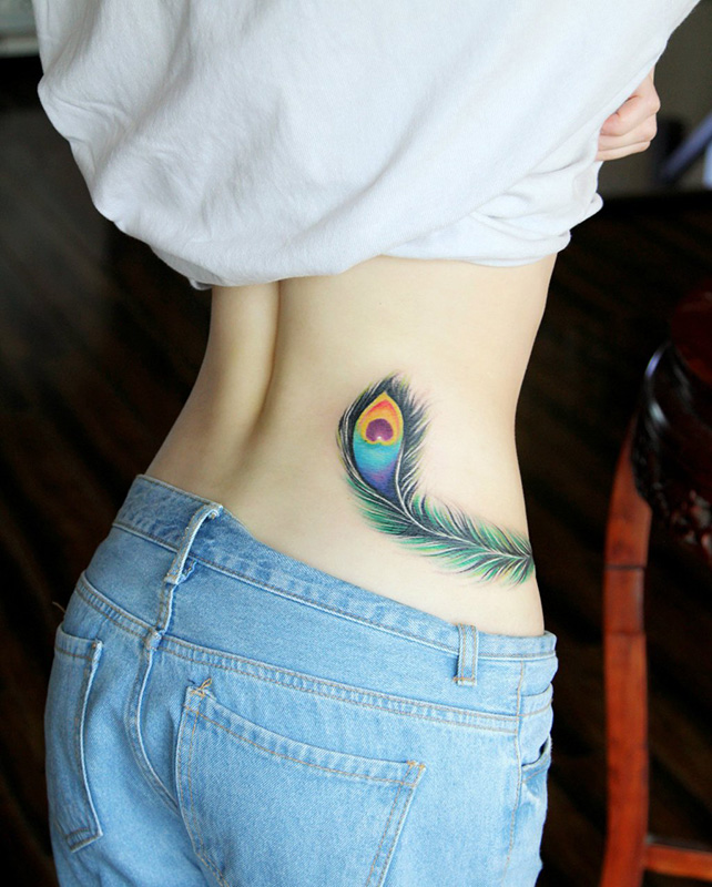 点击大图看下一张：女生腰部梦幻的彩色孔雀羽翎个性纹身图案