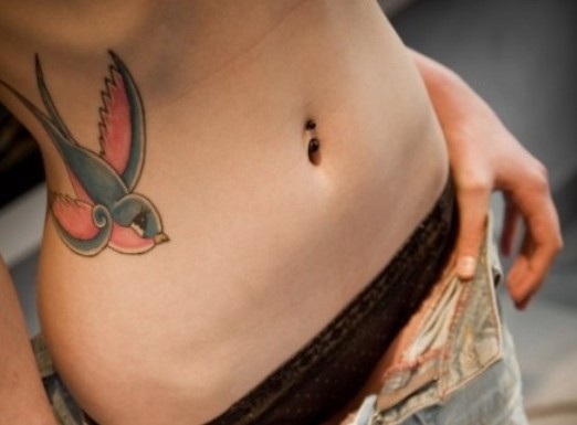 点击大图看下一张：女生腰部彩色燕子唯美纹身图案