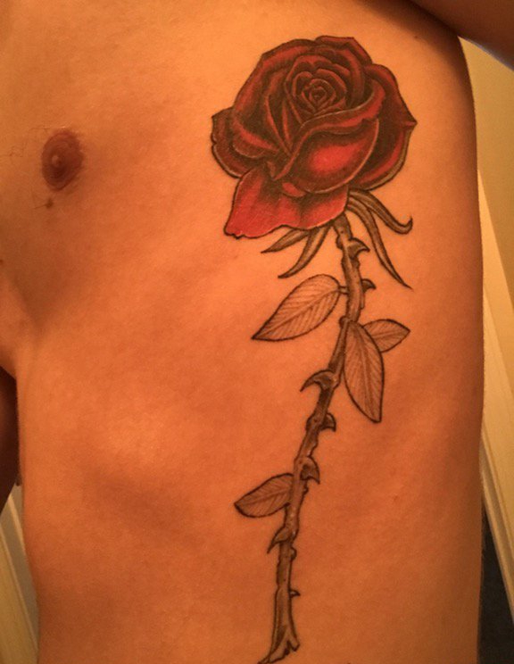 点击大图看下一张：男子侧肋上一束漂亮的玫瑰花纹身图片