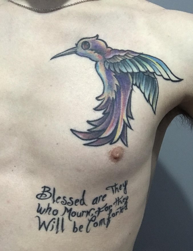 点击大图看下一张：男子左侧胸部上漂亮的蜂鸟和英文字纹身