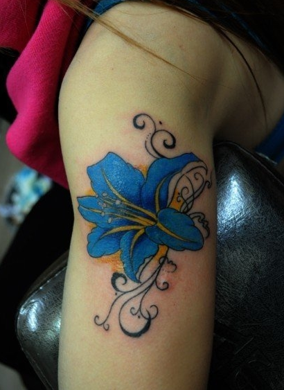 点击大图看下一张：女人手臂蓝色的百合花纹身图案