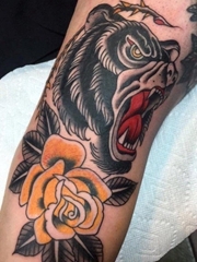 手臂上的传统风格黑熊和黄色玫瑰花纹身