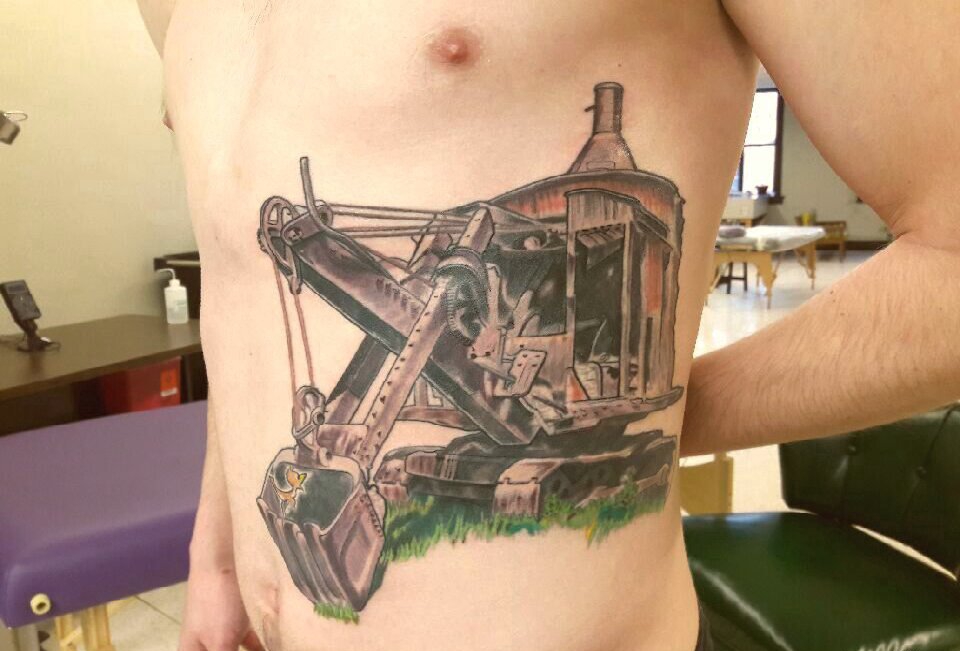 点击大图看下一张：男性侧肋上彩色老式挖土机器人纹身图片