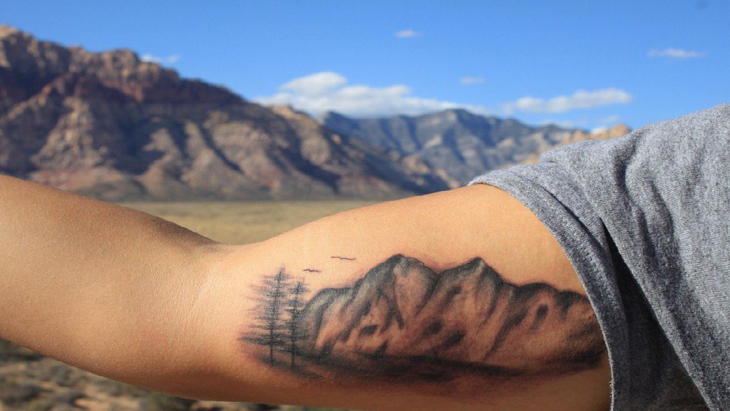 点击大图看下一张：手大臂上的现实风格山丘纹身图片