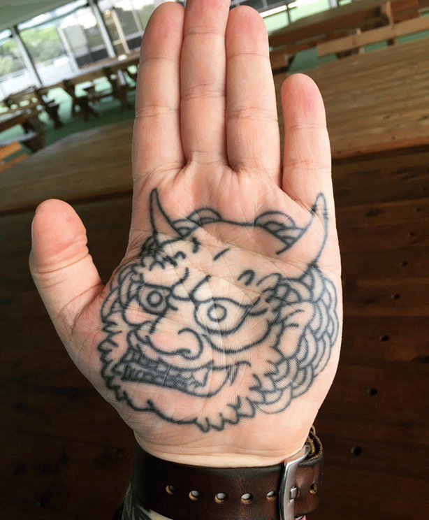 点击大图看下一张：男生手掌上纹身黑白灰风格石狮子纹身图片