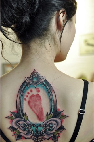 点击大图看下一张：美女背部小脚印花朵个性纹身图案