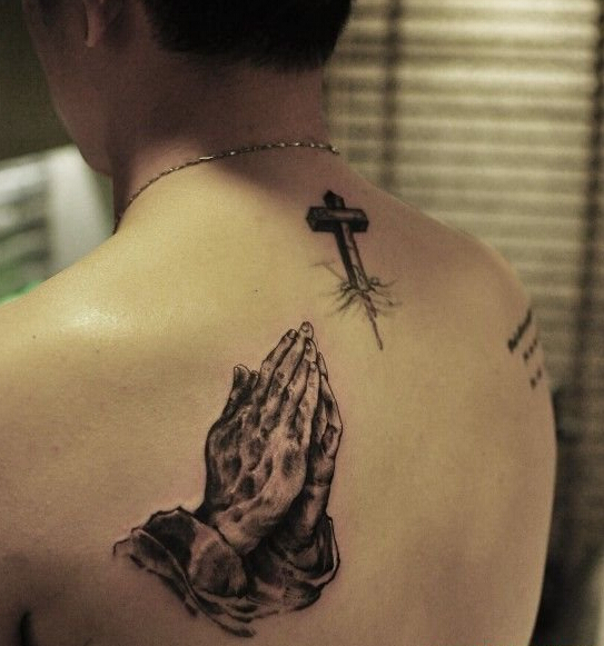 点击大图看下一张：男性后背双手祈祷十字架纹身图案