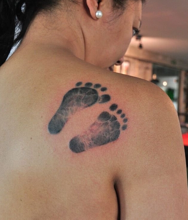 点击大图看下一张：背部创意可爱婴儿脚印纹身图案