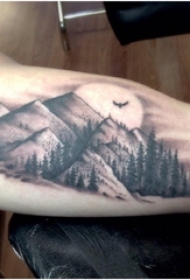 男生手臂上黑灰点刺技巧山和树风景纹身图片