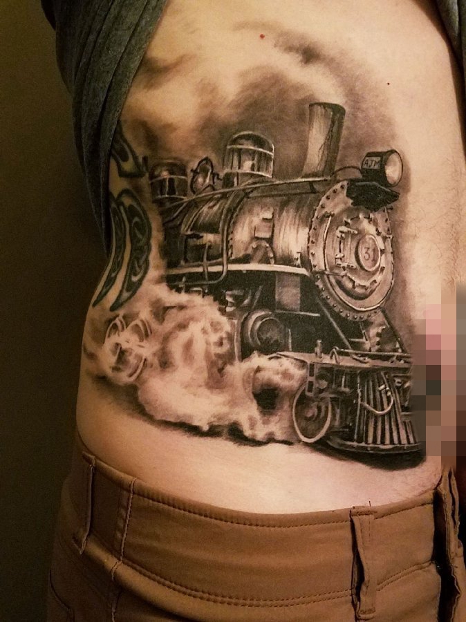 点击大图看下一张：男生侧腰上黑灰点刺技巧抽象线条火车头纹身图片