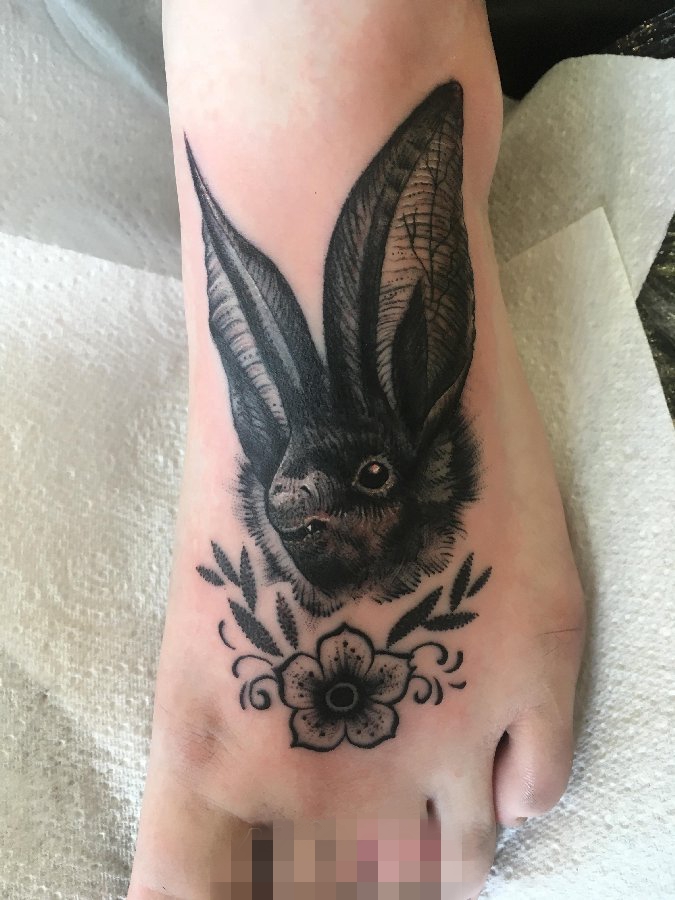 点击大图看下一张：女生脚背上黑色素描兔子与花朵纹身图片