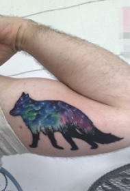 男生手臂上彩绘狼与星空纹身图片