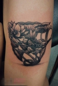 女生手臂上黑灰点刺技巧植物素材莲花和杯子纹身图片