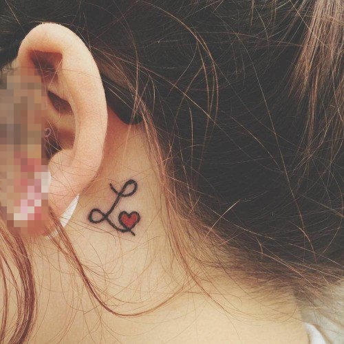 点击大图看下一张：女生耳后黑色花体英文和红色心形纹身图片