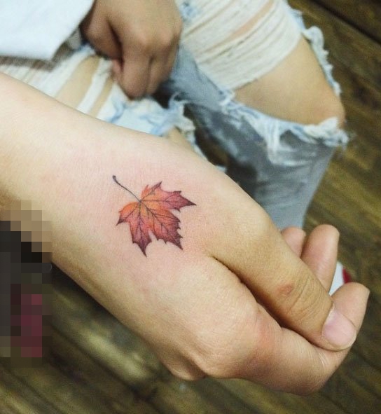 点击大图看下一张：女生手背上彩绘渐变植物素材枫叶纹身图片