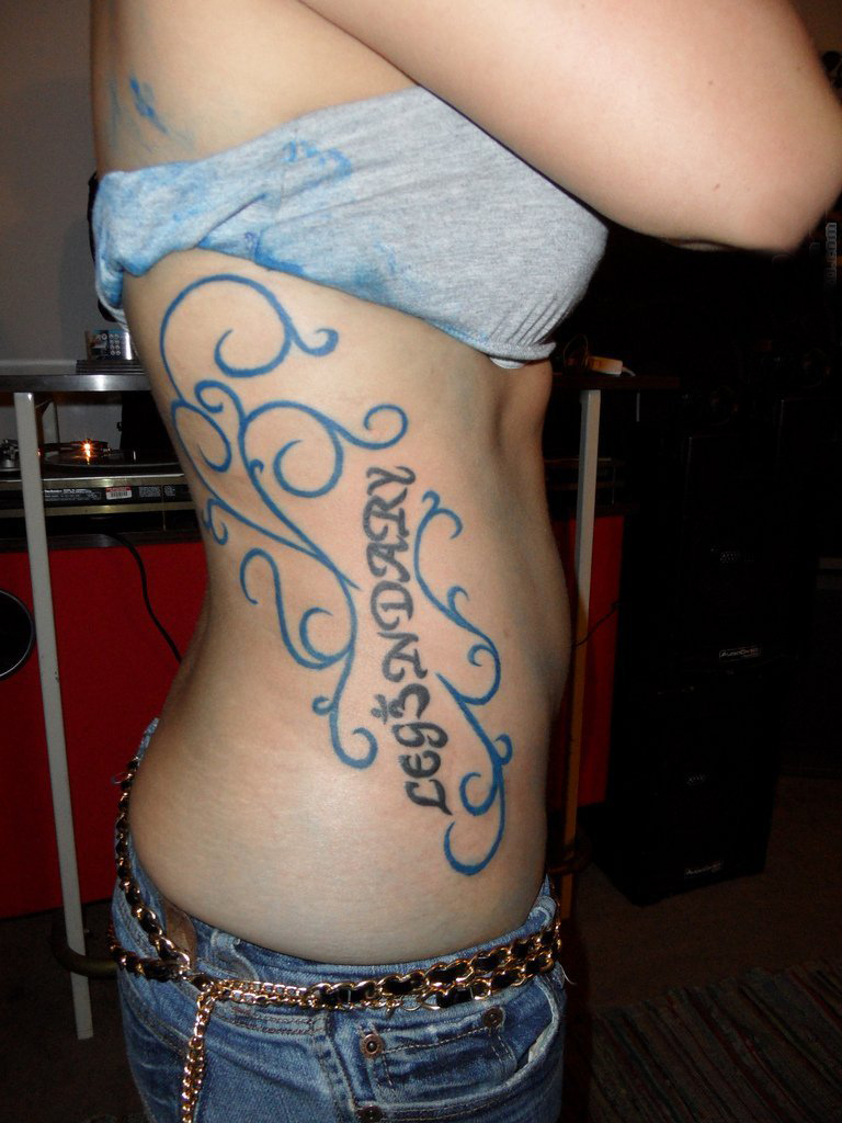 点击大图看下一张：女生侧腰上黑色线条创意图腾花体英文纹身图片