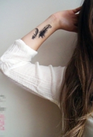 女生手腕上黑色点刺轻盈羽毛纹身图片