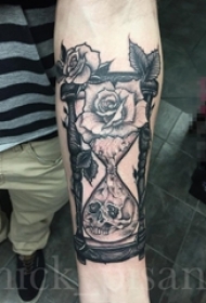 男生手臂上黑灰点刺植物花朵和沙漏纹身图片