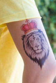 男生手臂上彩绘皇冠和黑灰点刺狮子纹身图片