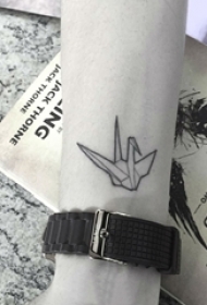 女生手腕上黑色几何线条千纸鹤纹身图片
