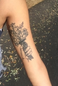 女生手臂上黑灰点刺手部和植物花朵纹身图片
