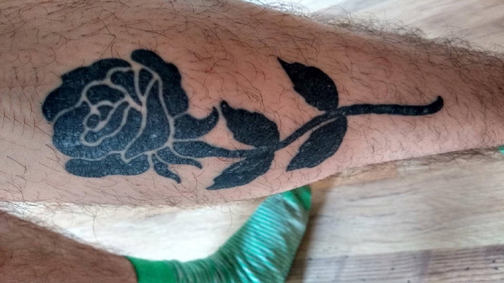 点击大图看下一张：男生小腿上黑色抽象线条植物叶子和花朵玫瑰纹身图片