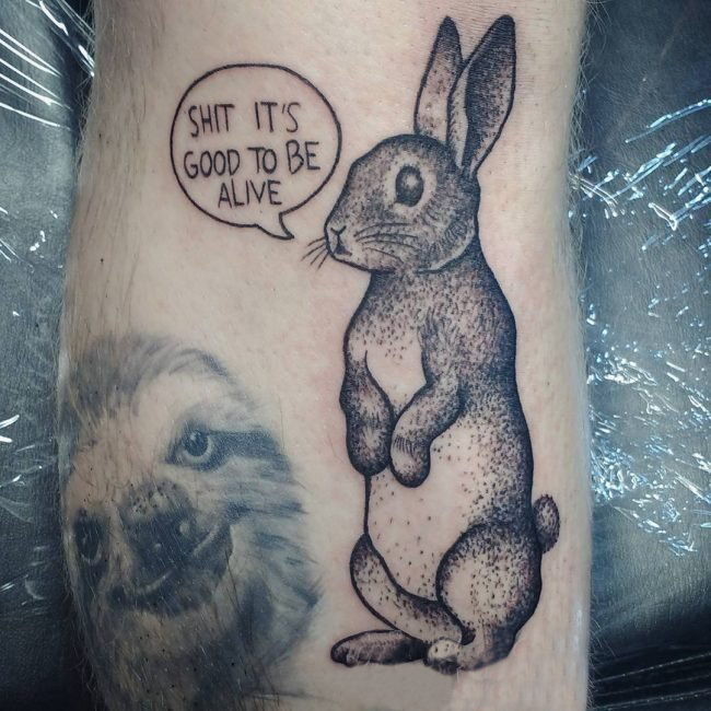 点击大图看下一张：男生小腿上黑色点刺简单线条英文和小动物兔子纹身图片