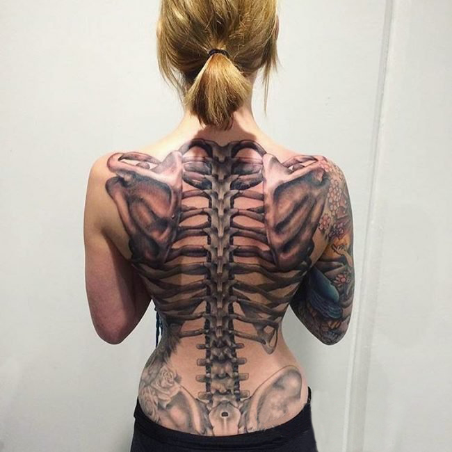 点击大图看下一张：女生背部黑灰素描点刺技巧创意大面积满背骨头纹身图片
