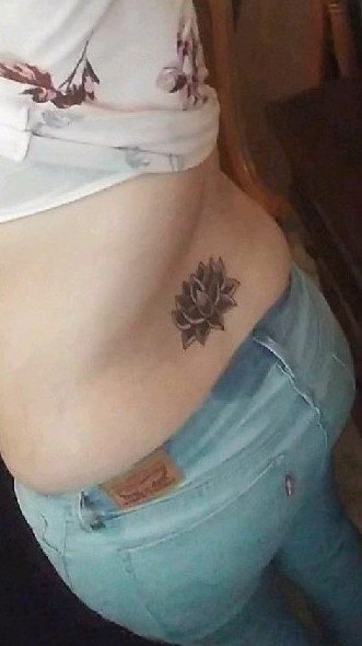 点击大图看下一张：女生后腰上黑灰点刺简单线条植物圣洁莲花纹身图片